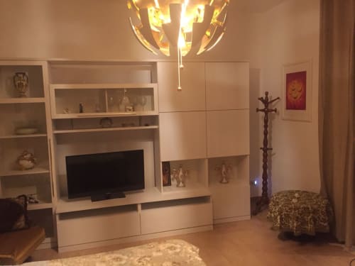 Modern living room in Lake View Panorama apartment at Gargazzone with white entertainment unit, flat-screen TV, shelving,
