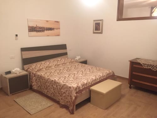 Spacious bedroom in Appartamento Giustina, Gargazzone with double bed, wooden furniture, and lake view artwork on walls