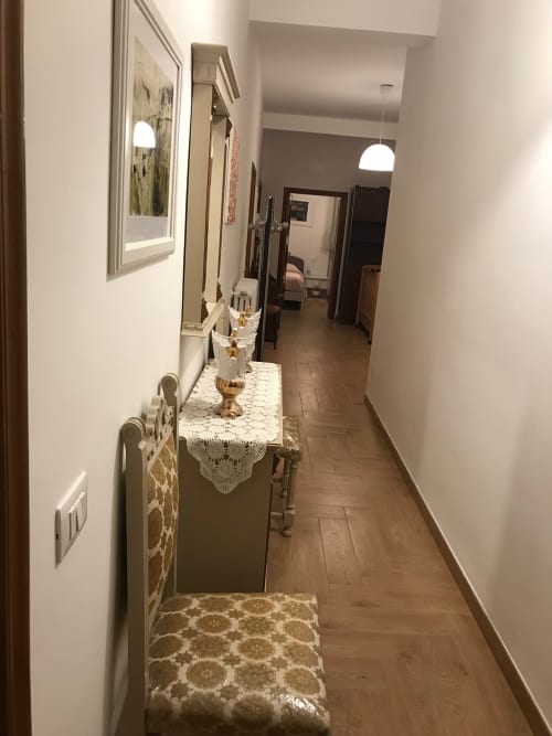 Elegant hallway at Appartamento Giustina with wood flooring, framed artwork, and decorative console table in Gargazzone