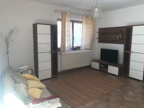 Modern living room in 2-bedroom apartment at Appartamento Giustina, Gargazzone, with TV, seating area, and mountain views