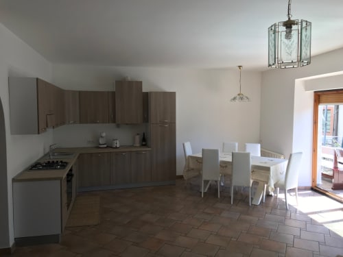 Modern kitchen and dining area in 2-bedroom ground floor apartment at Appartamento Giustina, Gargazzone with wooden cabinetry