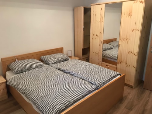 Spacious bedroom in 2 bedroom apartment at Appartamento Giustina in Gargazzone with double bed, pine wardrobe, and mountain