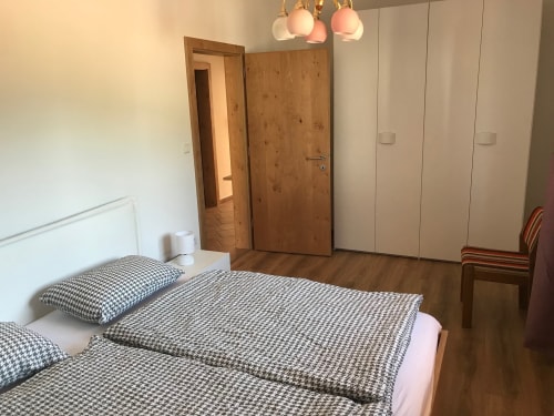Spacious bedroom in ground floor apartment at Appartamento Giustina with wooden doors, white wardrobes, and patterned bedding