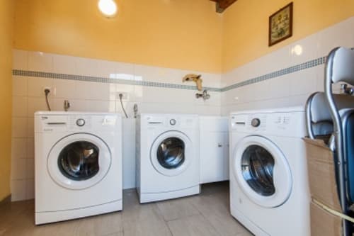 Laundry room with three white washing machines in Casa Vacanze Del Golfo apartment, Castellammare del Golfo, Sicily