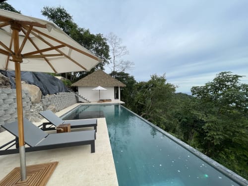 Piscine à débordement luxueuse à l'Organica Yoga Shelter à Puntarenas avec vue sur l'océan, transats et cabane au toit de chaume