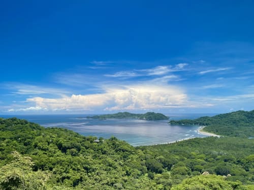Luxuriante canopée jungle surplombant une baie turquoise avec îles à Organica Yoga Shelter, Paquera, Costa Rica