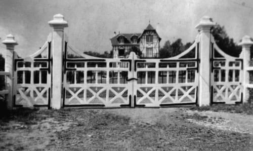 Entrée principale dans les années 30, histoire de la propriété,  portail en bois peint 
en blanc, ferrures peintes en noir, maison en arrière-plan au Domaine des Thomins Maison d'hôte Cisai Saint-Aubin Hôtel Gacé