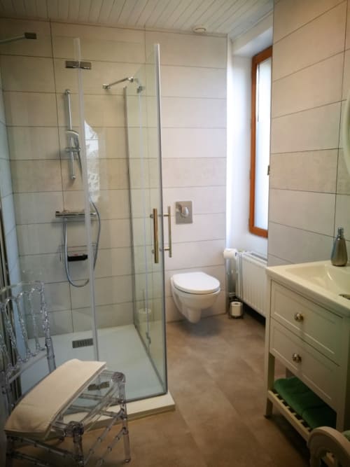 Modern bathroom at Aux Prés Du Berry in Chavin with walk-in shower, toilet, vanity sink, and warm beige tile finishes