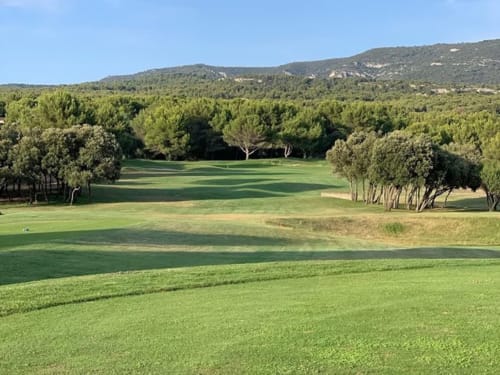 Fairway de golf bordé d'arbres avec collines boisées à Gordes, Provence