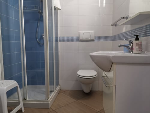 Modern bathroom in Studio Blu apartment at Casa Vacanze Del Golfo, Castellammare del Golfo, featuring blue tiled shower,