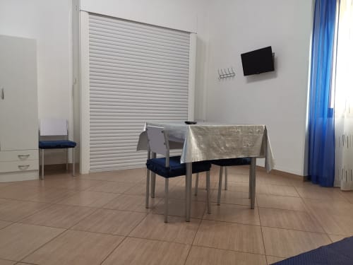 Studio Blu apartment at Casa Vacanze Del Golfo with dining table, chairs, wall-mounted TV, and modern amenities in