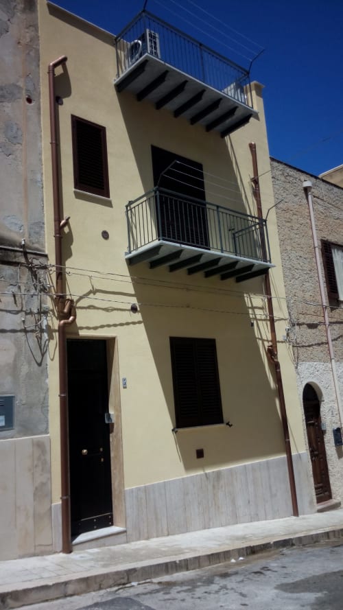 Affascinante facciata gialla di Casa Vacanze Del Golfo a Castellammare del Golfo con balconi e viste sulla terrazza