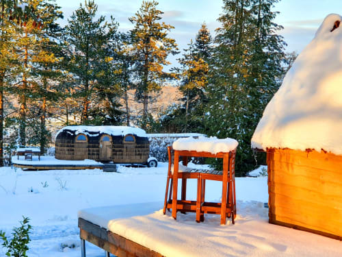Snow-covered cottage retreat at Les Refuges Du Chalet in Jalhay with vintage Airstream trailer and orange structures among
