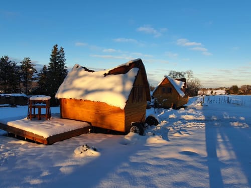 Charmantes Holzhaus verschneit bei Les Refuges Du Chalet, belgisches Gästehaus in Jalhay mit Blick auf verschneiten Garten