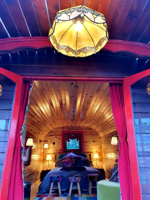 Cozy caravan bedroom at Les Refuges Du Chalet with wooden interior, brass chandelier, and pink entrance doors in Jalhay