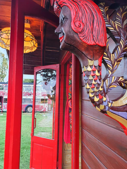 The Mermaid Caravan at Les Refuges Du Chalet in Jalhay with red neon-lit mermaid sculpture and ornate wooden door entrance.