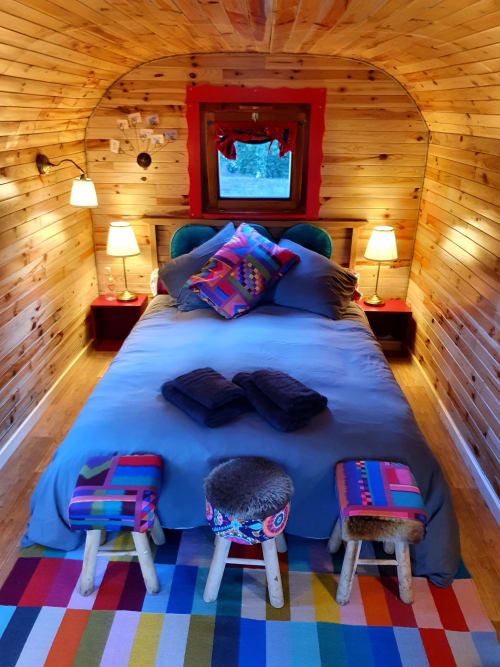 Cozy wooden cottage bedroom with colorful stools and blue bedding at Les Refuges Du Chalet in Jalhay