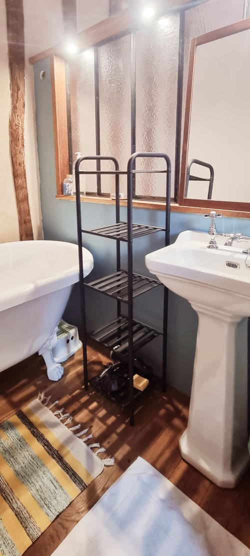 Salle de bains moderne à La Dragonne B&B à Bellême avec toilettes, lavabo, étagères noires et papier peint texturé