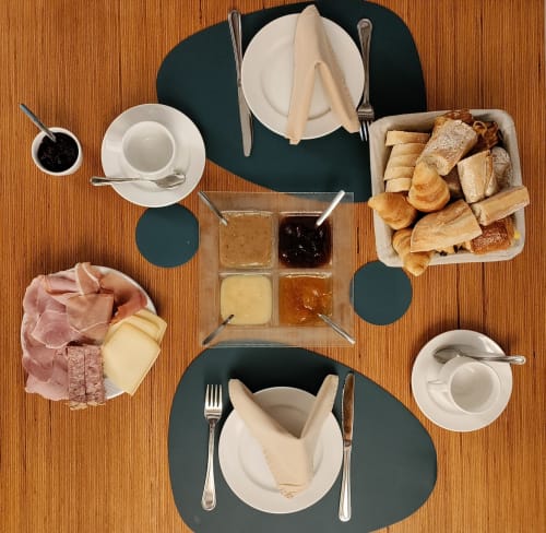 Breakfast spread at Le Moulin Des Ramiers in Crupet with pastries, meats, cheese, jams and place settings