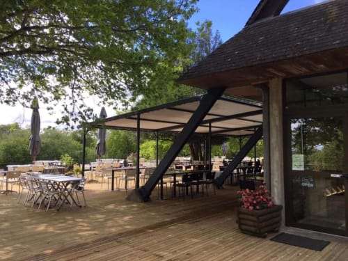 La terrasse extérieure de La Maison De Fleurat à Domeyrot avec coin ombragé, terrasse en bois et espaces de restauration