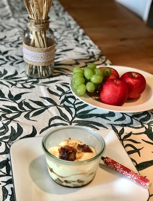 Table de petit-déjeuner élégante à La Maison de la Colline avec fruits, desserts et nappe à motifs à Vers, France