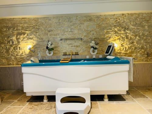 Luxueux spa extérieur aux eaux turquoise et contours blancs au gîte Vue Sur Gindou, Gindou, avec mur teinté or