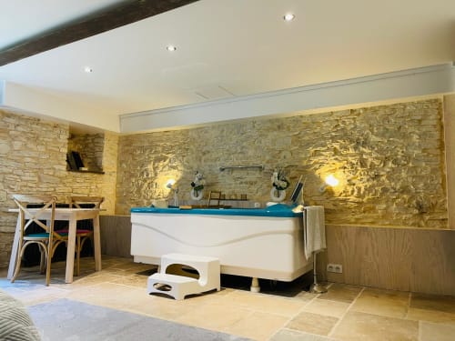 Chalet spa avec baignoire chaude, table à manger et murs en pierre à Vue Sur Gindou & Clos Sandrine, Gindou