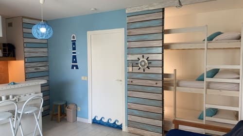 Chambre à coucher au style nautique avec murs bleus, lits superposés, décoration phare et miroir hublot chez Caribluewave