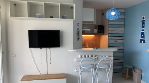 Cuisine moderne et salon avec télévision écran plat, bar et décor nautique bleu à Caribluewave