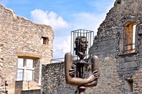 Bronze sculpture installation within historic stone ruins at Provence Km28 in Gordes, France