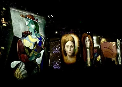Night gallery display of classical and modern portrait paintings at Provence Km28 boutique hotel in Gordes