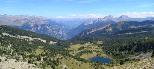 Paysage de vallée alpine près de Le Lauzet-Ubaye avec pics montagneux, forêts et lacs cristallins