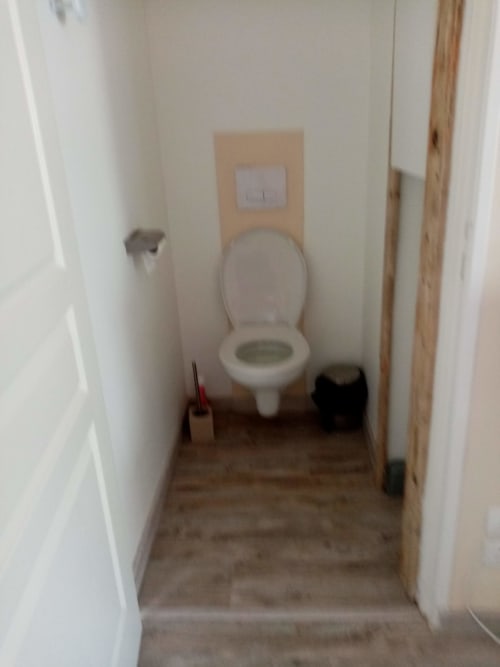 Petite salle de bain avec toilettes blanches, interrupteur et carrelage marron dans la chambre luxe de Varette Patricia Les Clématites