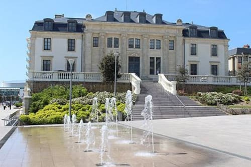 Hôtel Maison Richet in Les Sables-d'Olonne with grand facade, fountains, and manicured gardens under blue sky