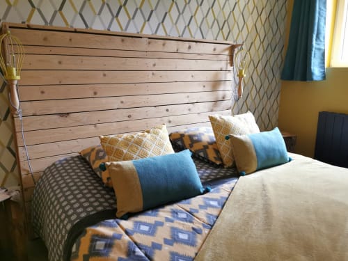 Chambre de la maison d'hôtes La Cour d'Hortense avec tête de lit bois, coussins motifs et vue sur jardin à Sailly-Flibeaucourt