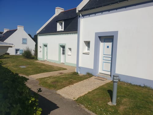 Résidence 34, vue extérieure à Loc'Maria, Belle Île en Mer - appartement côtier aux murs blancs et porte bleue