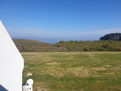 Vue du jardin côtier à Locmaria Belle Île en Mer avec paysage littoral et coin salon aménagé