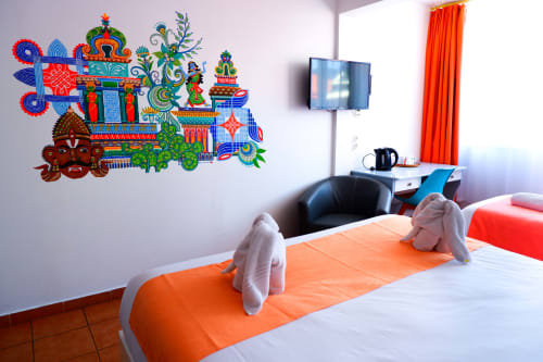 Chambre colorée à l'Hôtel du Cirque de Cilaos avec art mural vibrant, lits jumeaux, bureau, TV et coin détente