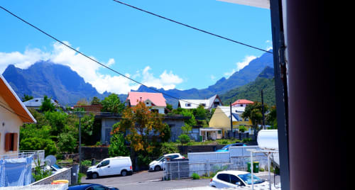 Vue montagne depuis l'Hôtel du Cirque à Cilaos, bâtiments colorés du village nichés dans la vallée