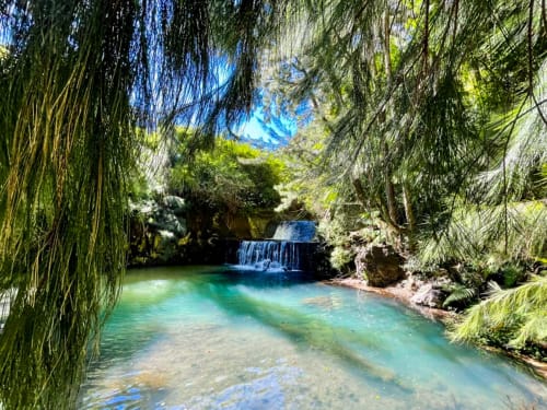 Bassin de cascade turquoise entouré de verdure luxuriante à l'Hôtel du Cirque, Cilaos, Réunion