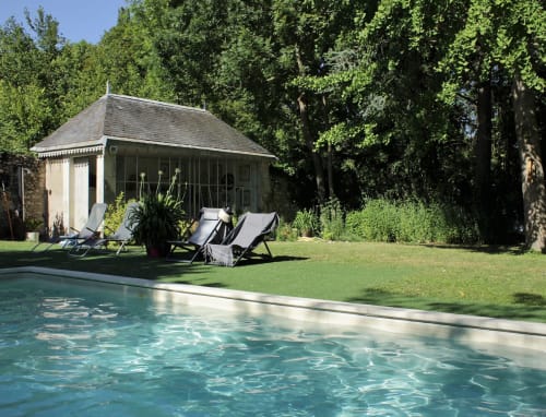 Swimming pool with loungers at Les Rives De La Tronne hotel in Mer, France, surrounded by trees