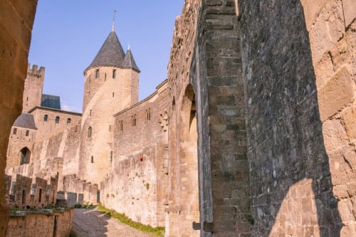Forteresse médiévale à Montséret, France avec tours et murailles en pierre sous un ciel bleu dégagé