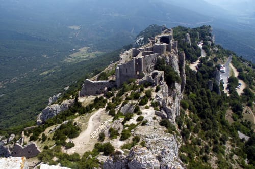 Ruines d'un château médiéval sur un sommet rocheux dominant une vallée verdoyante près de Montséret, France