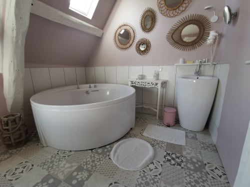 Salle de bains moderne à La Cour d'Hortense avec baignoire circulaire, lavabo sur pied et miroirs décoratifs à Sailly-Flibeaucourt