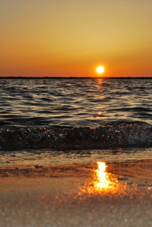 Coucher de soleil doré sur les vagues océanes à Sylvie CAMBON, Montséret - vue côtière de plage au crépuscule