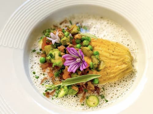 Gouden kurkumarijke eiergerecht met erwten, groenten en eetbare bloemen bij Provence Km28 Gordes