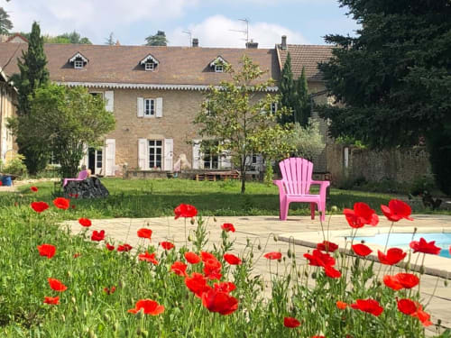 Vue du Clos Ayanna depuis le jardin, piscine et chaise de jardin. 