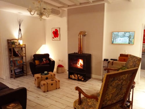 Cozy living room at Aux Prés Du Berry B&B with fireplace, beige walls, and vintage furnishings in Chavin, France
