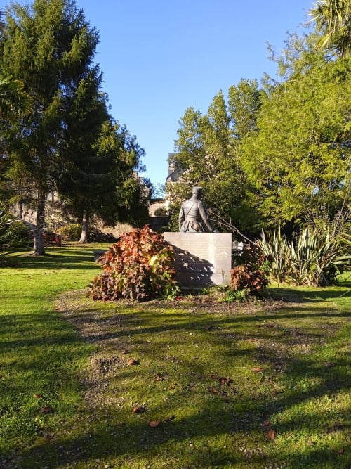Statue de pierre dans un jardin luxuriant aux Clématites en Cotentin, hôtel Saint-Flocel entouré d'arbres
