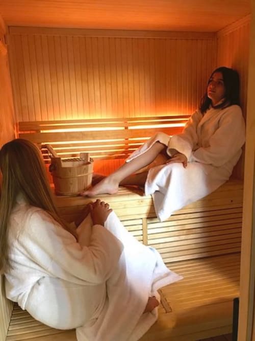 Two women enjoying a sauna at Les Maisons de Chamirey luxury B&B in Mercurey, France